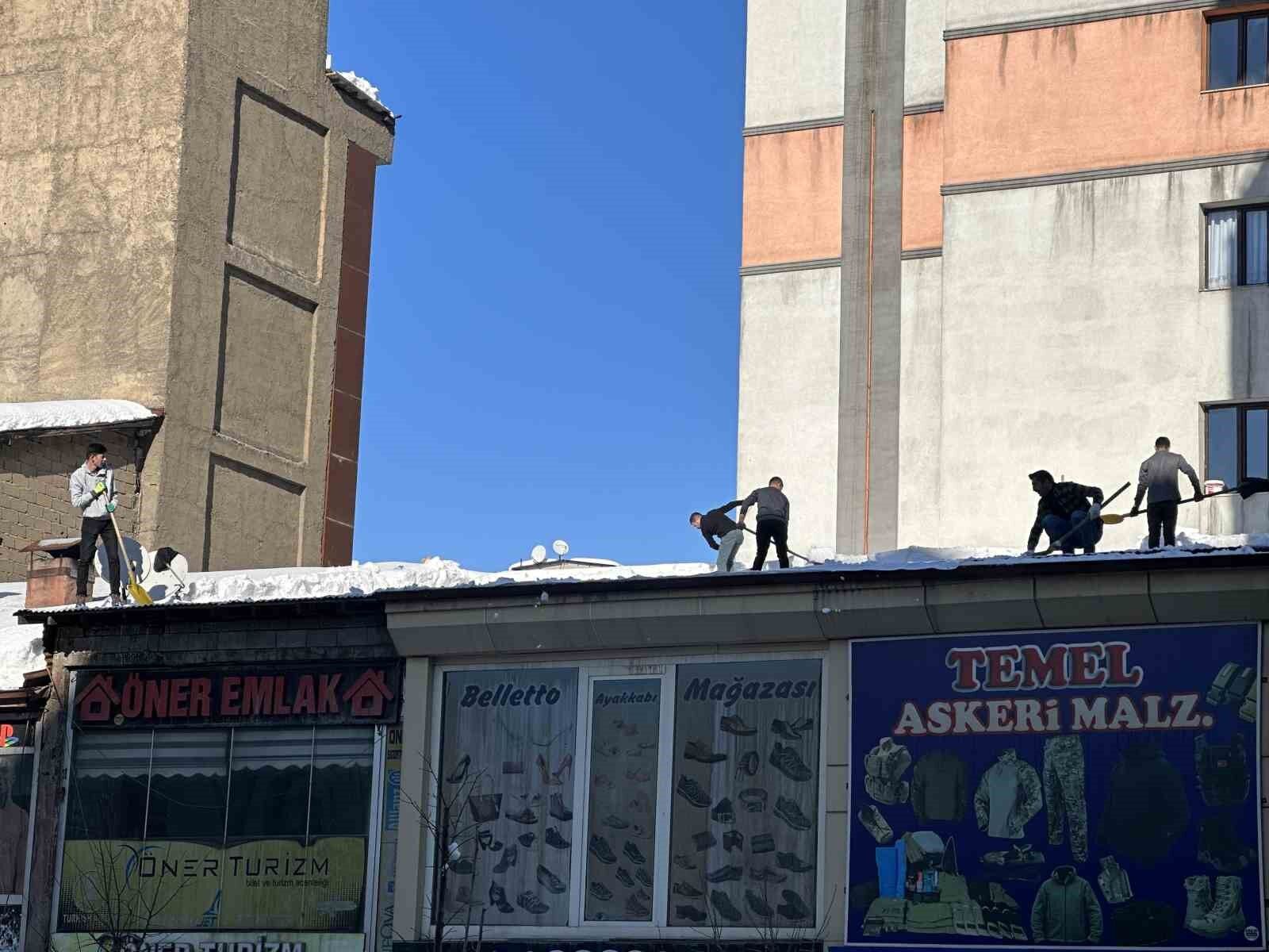 Vatandaşlar çatıdaki kar kütlelerini brandayla indirdi