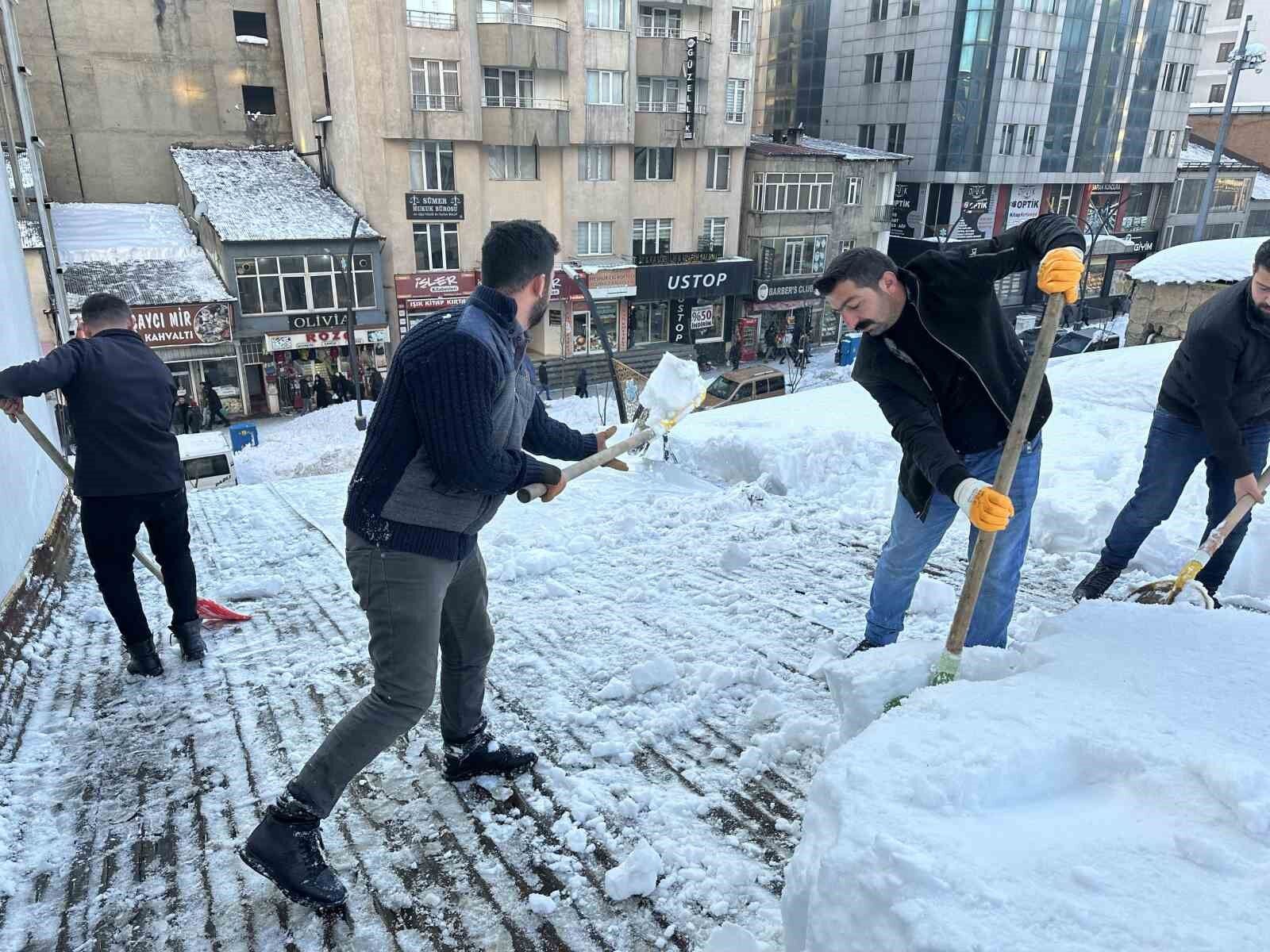 Vatandaşlar çatıdaki kar kütlelerini brandayla indirdi