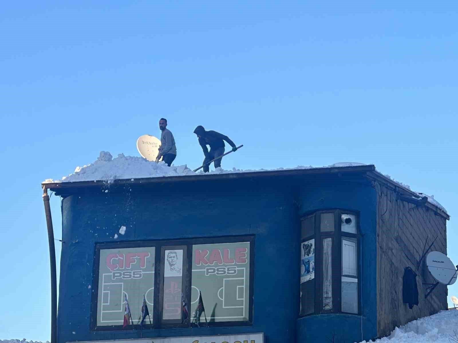 Vatandaşlar çatıdaki kar kütlelerini brandayla indirdi