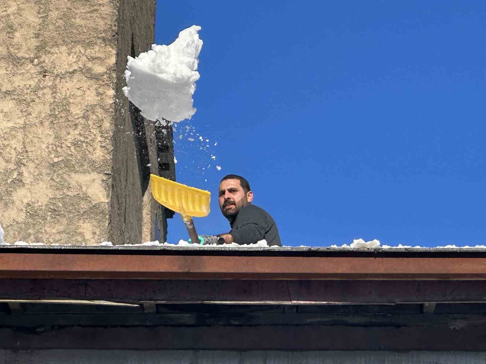 Vatandaşlar çatıdaki kar kütlelerini brandayla indirdi