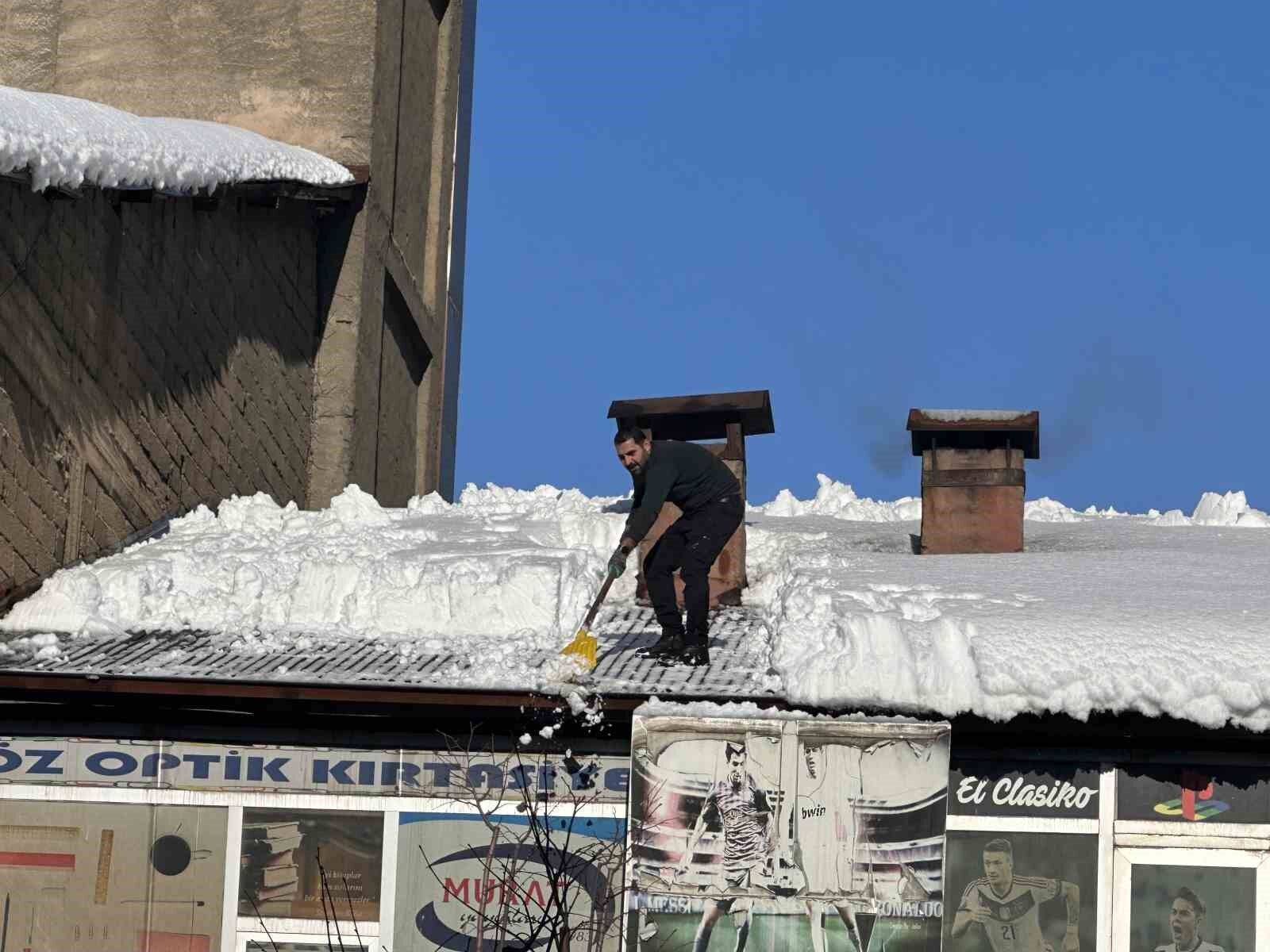 Vatandaşlar çatıdaki kar kütlelerini brandayla indirdi