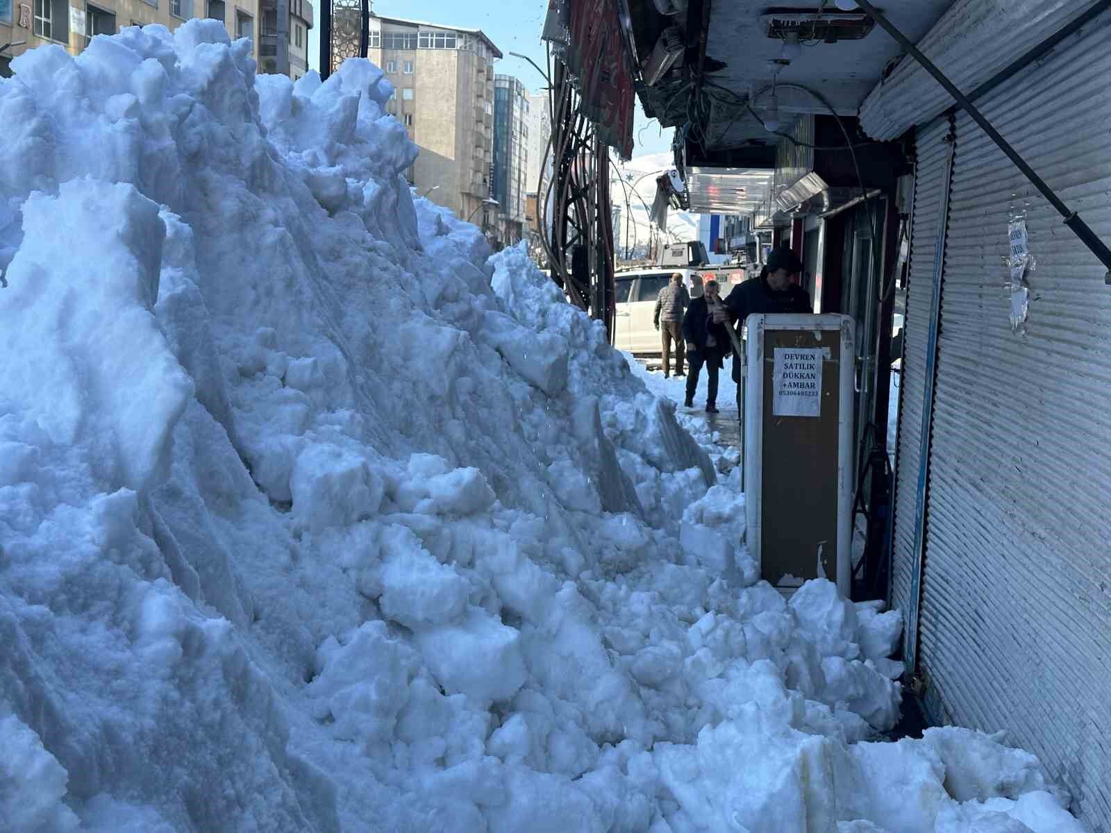 Vatandaşlar çatıdaki kar kütlelerini brandayla indirdi